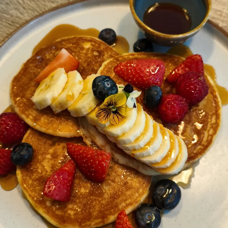 Pancakes with banana, berries and maple syrup